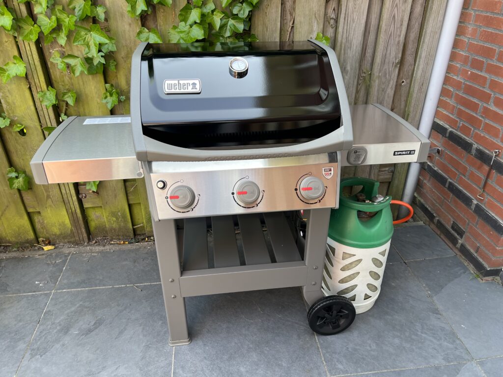 Fully assembled Weber Spirit II E-310 with a propane tank